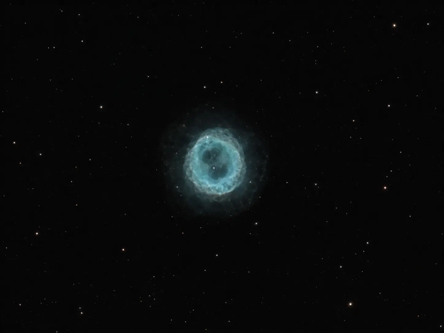 The pale cyan shell of the Owl Nebula