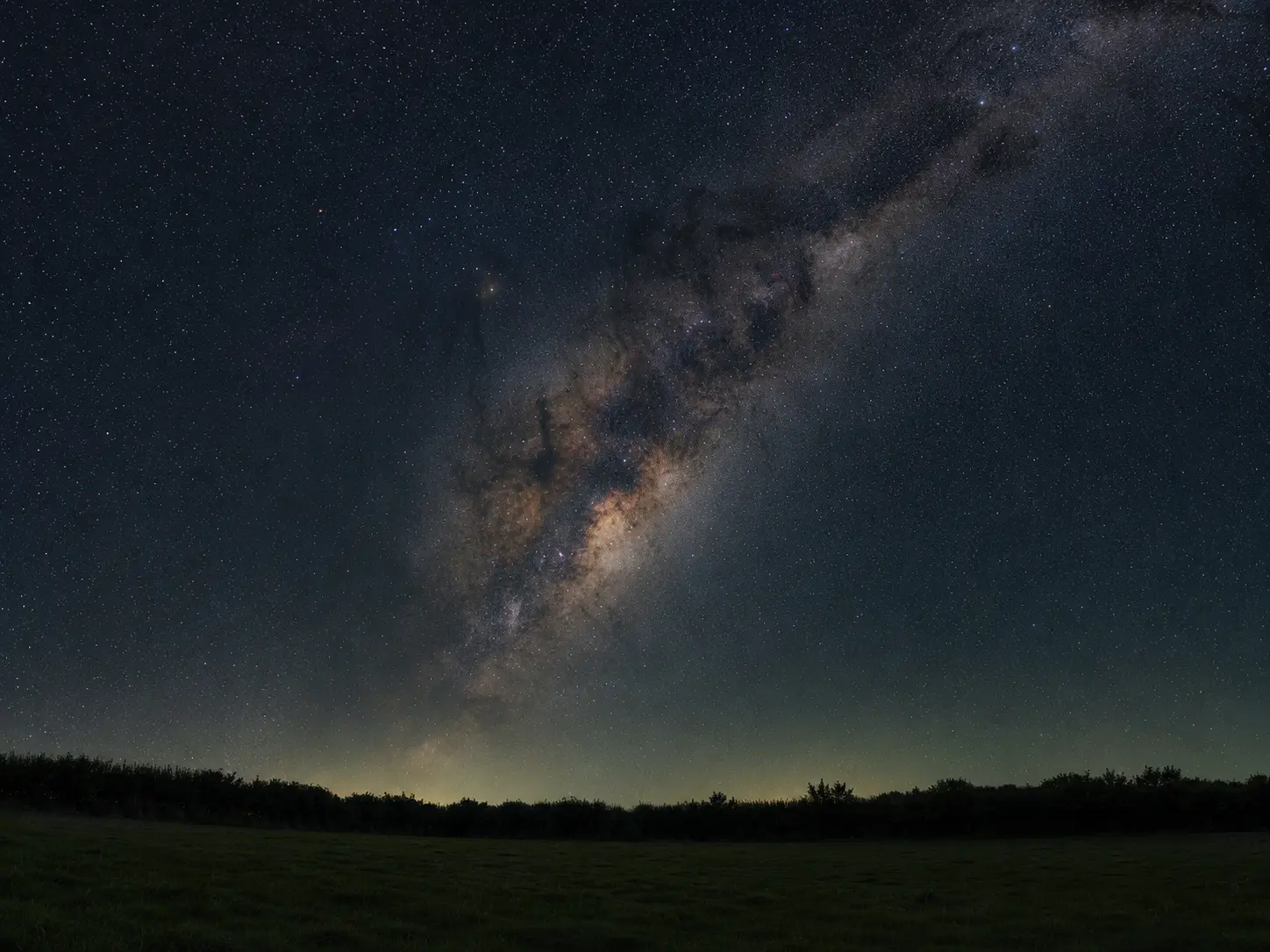 The Milky Way rising over a quiet rural field