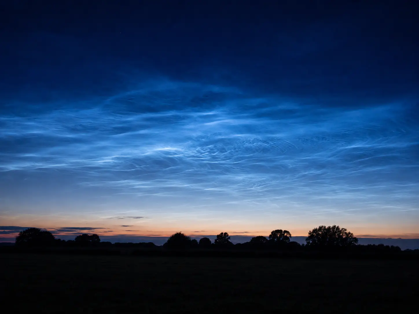 Silver-blue noctilucent clouds at summer twilight